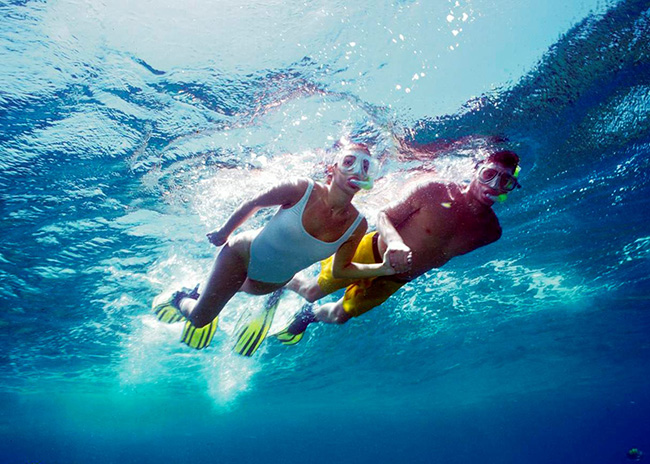 Lucy and her boyfriend snorkeling on the surface of the sea in Cozumel.